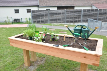 -Das erhöhte Duftbeet aus Holz mit verschiedenen Pflanzen und Stauden für vestibuläre Reize.